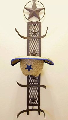 a metal sculpture with a cowboy hat on it's head and stars above the top