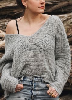 a woman standing in front of a pile of logs with her hands on her hips