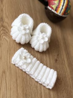 two crocheted baby booties sitting on top of a wooden table