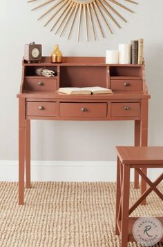 a desk with a clock on the wall above it