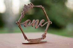 a metal piece with the word love on it sitting on top of a wooden table