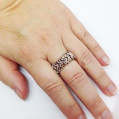 a person's hand with a ring on it that has three letters in the middle