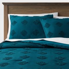 a bed with teal blue comforters and pillows