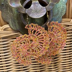 two metal vases sitting on top of a wicker basket