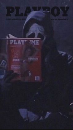 a person wearing a mask and holding a book in front of their face with the words play me on it