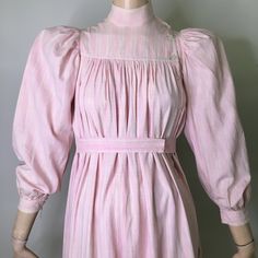 "This is a antique wrapper from the late 1800's (1870s-1890s). It is pink and white plaid cotton. Pink is pretty unusual as most of these are usually indigo or brown. I love the tent like style of this dress and how wearable it is without looking like you are wearing a costume. Often period dresses look period, the color, fabric and cut of this dress are very much now. It looks like the fabric could be homespun. The dress has mandarin style stand collar with an asymmetrical button neck opening. Cottagecore Victorian Dress For Daywear, Victorian Cotton Prairie Dress For Spring, Victorian Cotton Prairie Dress For Daywear, Spring Cotton Regency Prairie Dress, Spring Regency Style Cotton Prairie Dress, Cotton Victorian Cottagecore Dress For Daywear, Cottagecore Victorian Cotton Dress For Daywear, Feminine Cotton Vintage Dress For Daywear, Cotton Victorian Dress In Cottagecore Style For Spring