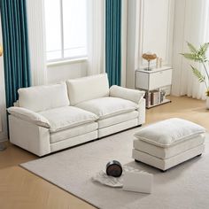 a living room with white furniture and blue curtains