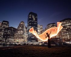 a woman standing in front of a city skyline at night