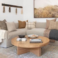 a living room with a couch, coffee table and pictures on the wall above it