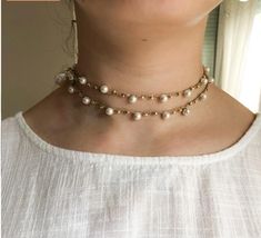 This elegant double-strand pearl necklace is perfect for adding a special touch to any outfit. Its design combines pearls and gold beads, and has a beautiful detail that falls down the back, ideal for wearing with dresses or tops with a low back. Characteristics: Materials: Synthetic pearls, gold beads, braided thread. Style: Double turn with drop at the back. Adjustable length to fit different necklines. Perfect for special occasions or to add a chic touch to your everyday life. This necklace i Party Layered Pearl Necklace With Pearl Chain, Pearl Chain Layered Choker Necklace For Party, Pearl Chain Layered Choker For Party, Gold Double Strand Pearl Necklace, Party Pearl Chain Choker Necklace, Gold Beaded Pearl Layered Necklace, Gold Pearl Beaded Layered Necklace, Gold Choker With Pearl Charm For Party, Elegant Pearl Layered Necklace With Pearl Chain