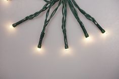 a bunch of lights that are on top of a white surface with green wires attached to them