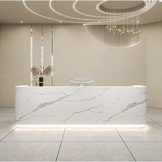 a white marble counter top sitting in front of a chandelier