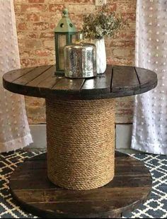 a round table with rope wrapped around it on top of a rug in front of a brick wall