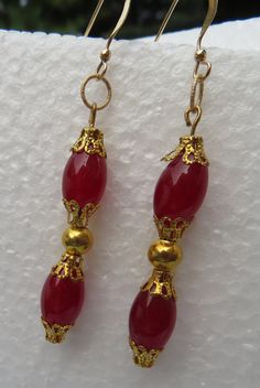 "Deep ruby red carnelian earrings...semi precious natural stones that sway with every movement as you dance the holiday away! The 8mm x 12mm barrel shaped carnelian beads are accented with goldplate lacy bead caps, separated with yellow goldplate 5mm round beads.  Gemstone and gold earrings drop 2 3/4\" from 14k gold filled French wires. These earrings coordinate with carnelian necklace also found in this shop." Elegant Gemstone Beaded Earrings For Gift, Elegant Gold Earrings With Polished Beads, Elegant Gold Carnelian Earrings, Elegant Agate Gemstone Bead Earrings, Elegant Party Earrings With Polished Beads, Red Spiritual Jewelry With Gold Beads, Elegant Polished Beads Earrings For Party, Spiritual Red Jewelry With Gold Beads, Gold Carnelian Dangle Earrings