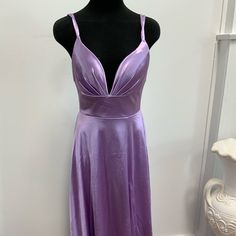 Brand New , Never Been Worn Dress . This Beautiful Lavender Gown Is Long And Body Forming But Flows On The Bottom , It Has Straps On The Back For Added Detail And Padding In The Front For Extra Comfort. This High Quality Satin Material Is So Soft And Feels Great On The Body . Makes For A Beautiful Evening Gown For An Outing Or For Any Special Event . Lavender V-neck Dress For Formal Occasions, Lavender V-neck Dress For Prom, Lavender Dress For Spring Homecoming, Lavender A-line Prom Dress, Lavender V-neck Bridesmaid Dress, Purple V-neck Homecoming Dress, Purple Satin Sleeveless Maxi Dress, Sleeveless Purple Satin Maxi Dress, Purple Floor-length Dress For Homecoming