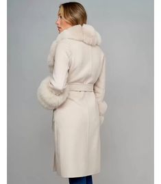 Petra Beige Fox Fur Trim Long Wool Wrap Coat with Waist Tie for Women - Slim Fit Women's woolen overcoat with a long length for a stylish and elegant look. Features a large turn-down collar with fox fur detailing for added flair. The sleeves also feature fox fur accents, adding a touch of luxury. Includes a waist belt for a customizable fit, enhancing the overall silhouette. 2 deep and functional side pockets for easy storage while wearing Made from high-quality wool for exceptional warmth and c Elegant Fitted Beige Wool Coat, Fitted Long Beige Sweater Coat, Cream Fitted Long Wool Coat, Fitted Long Cream Wool Coat, Elegant Winter White Wool Coat For Fall, Elegant Cream Fur Coat With Long Sleeves, Elegant Long Coat In Winter White, Elegant Long Winter Pea Coat, Elegant Long Sleeve Cream Fur Coat