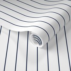 a white and blue striped wallpaper with lines on the bottom, along with a roll of tape