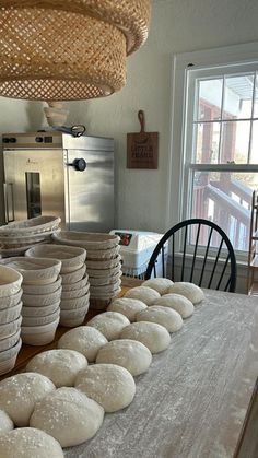 stacks of uncooked bread sitting on top of a table next to a window