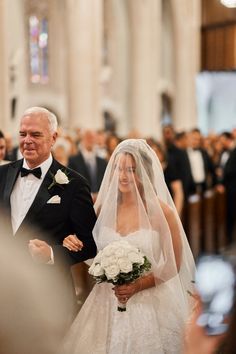 an older man and woman are walking down the aisle at their wedding ceremony in church