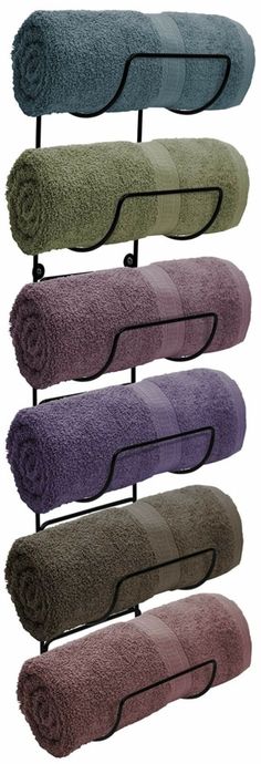 four towels hanging on a rack in different colors and sizes, each with a towel holder