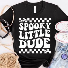 a t - shirt that says spooky little dude on it next to some shoes