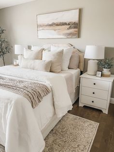 a white bed sitting in a bedroom on top of a hard wood floor