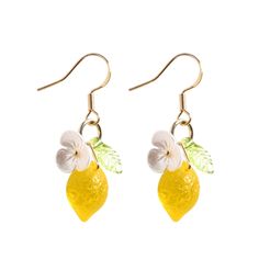 two lemons with leaves and flowers hanging from earwires on white background photo