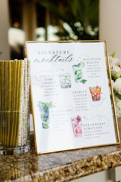 a sign that is sitting on top of a table with flowers in the vases