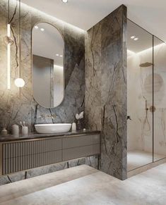 a bathroom with marble walls and flooring is pictured in this image, it has a large mirror on the wall