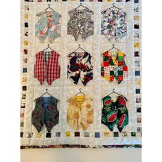 a quilted wall hanging with different types of clothing on it's hangers