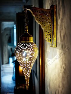 a light fixture hanging from the side of a wall in a hallway next to a doorway