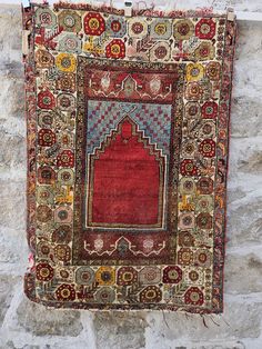 an old rug hanging on a stone wall