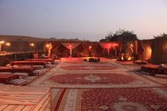 an outdoor area with lots of rugs and lights