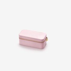 a small pink case with gold zippers on the front and bottom, sitting against a white background