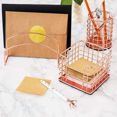 two office supplies sitting on top of a white counter next to a pen and pencil holder