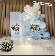 balloons and flowers are on display in front of a sign that says happy birthday with the number fifteen