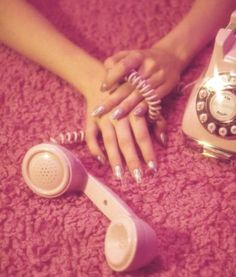 a woman laying on the floor next to an old fashioned phone and hairdryer