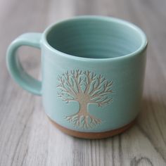 a cup with a tree on it sitting on a table