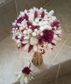 a bouquet of flowers sitting on top of a tiled floor