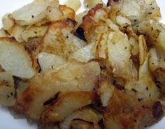 cooked potatoes on a white plate with some seasoning sprinkled around the edges