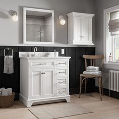 a bathroom with black and white walls, wooden floors and two mirrors on the wall