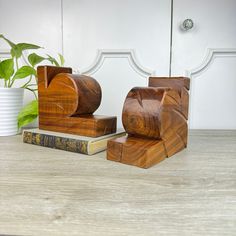 two wooden bookends sitting on top of a table next to a potted plant