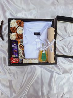 an assortment of items in a box on a bed