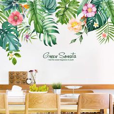 a dining room wall with tropical leaves and flowers on it