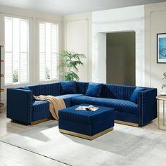 a living room with blue couches and white rugs on the hardwood flooring