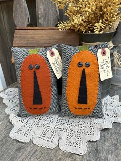 two orange and black pillows sitting on top of a wooden table