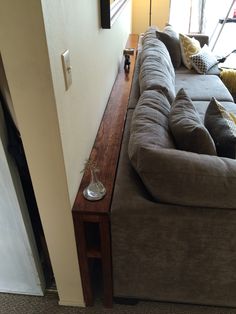 a long couch sitting next to a wooden table