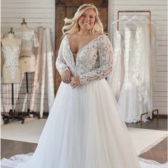 a woman in a wedding dress posing for the camera with her hands on her hips