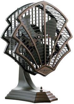 an old fashioned fan is sitting on top of a metal stand and it's turned upside down