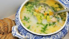 a blue and white bowl filled with soup next to crackers